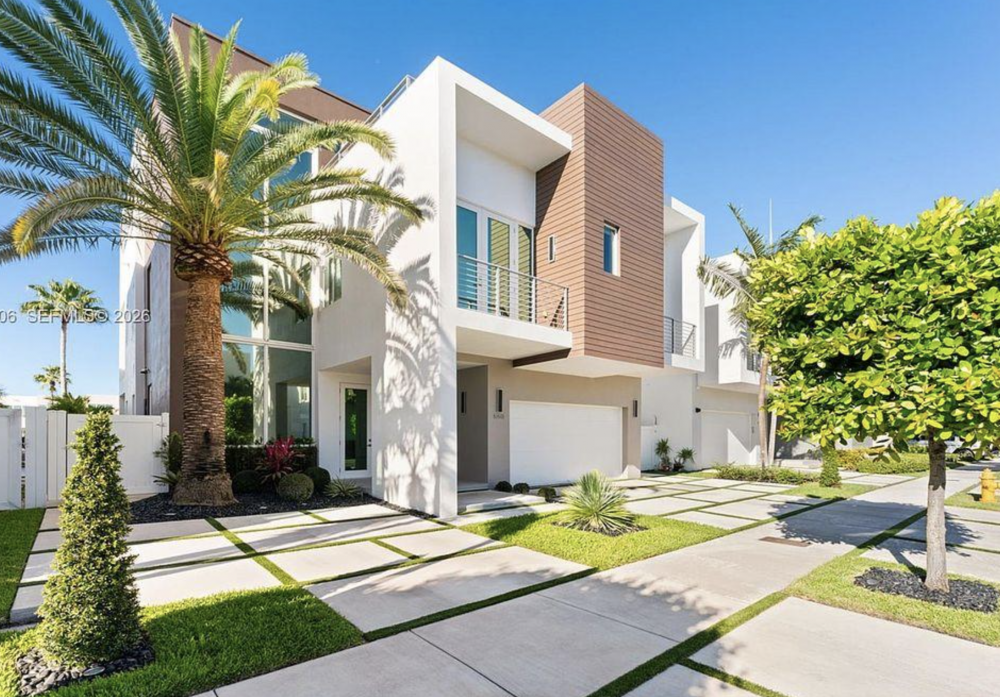Modern luxury home in Doral Florida with palm trees and landscaped driveway